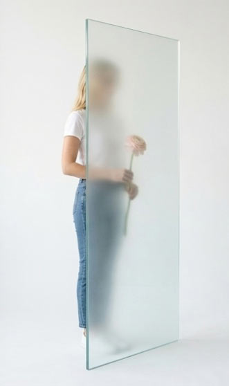 Frau hinter MIlchglasfolie mit Rose in der Hand